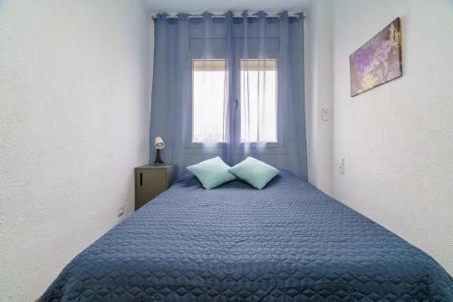 a bedroom with a blue bed with two pillows at El Nido in Gavà