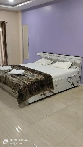 a large bed in a room with a bed frame at Saisha Palace Hotel, Ganpatipule in Ganpatipule