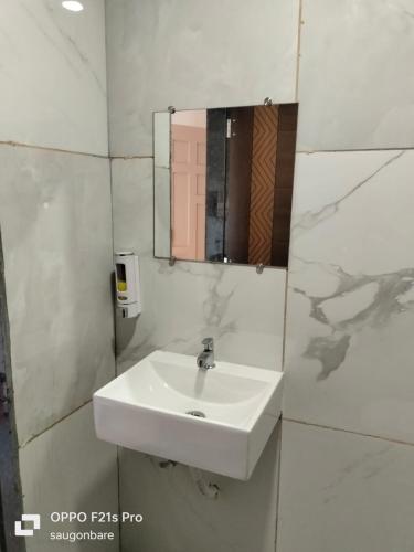 a bathroom with a sink and a mirror at Saisha Palace Hotel, Ganpatipule in Ganpatipule
