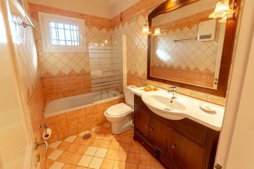 a bathroom with a sink and a toilet and a mirror at 2-BR Apartment by the Sea in Paramonas