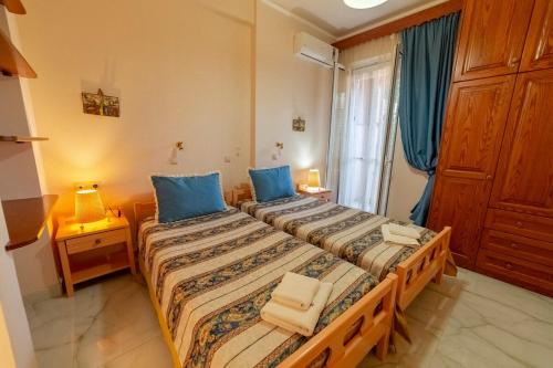 a bedroom with two beds with blue pillows at 2-BR Apartment by the Sea in Paramonas