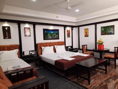 a bedroom with two beds and a table and chairs at Ango Plaza Hotel in Kovilpatti
