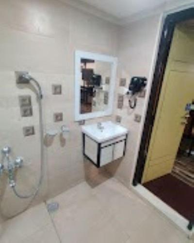 a bathroom with a shower and a sink and a mirror at Ango Plaza Hotel in Kovilpatti