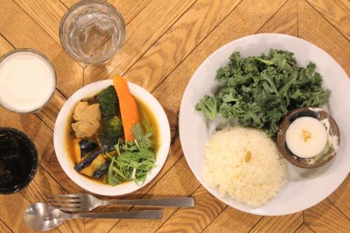 a wooden table with two plates of food on it at HakoBA Hakodate by THE SHARE HOTELS in Hakodate