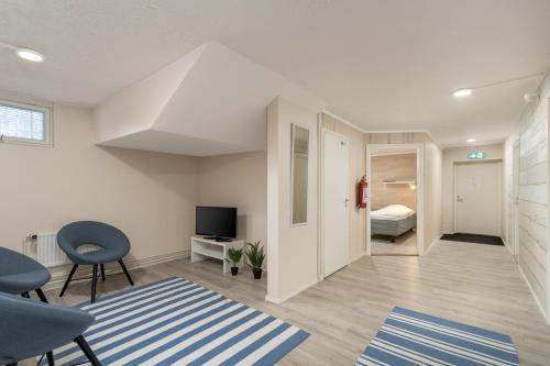 a living room with a room with a bed and a tv at Jääskän Loma, Kojolapark Luiska-hostelli in Voltti