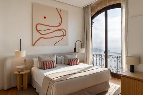 a bedroom with a large bed and a large window at Parador de Ibiza in Ibiza Town