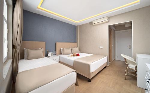a hotel room with two beds and a table at Begovina in Marmaris