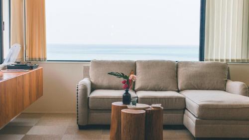 a living room with a couch and a table at Blue Steak Wonder Nagahama in Yomitan