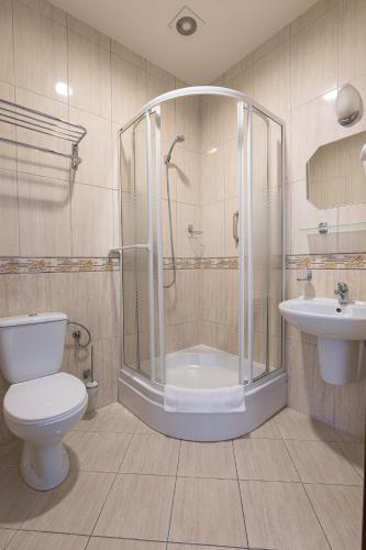 a bathroom with a shower and a toilet and a sink at Royal Park Hotel & Spa in Mielno