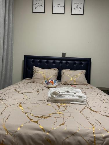 a bed with a black headboard and some pillows at Lex Place Syokimau in Syokimau
