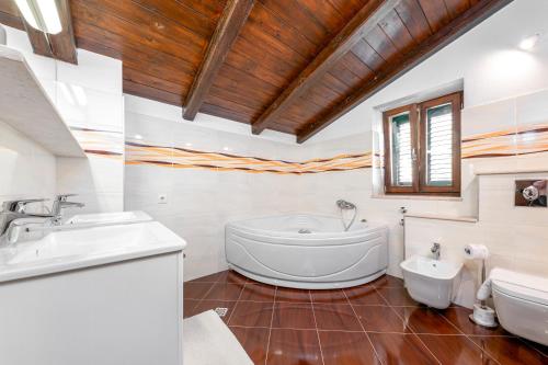 a bathroom with a tub and a sink and a toilet at Brela Seaview Apartment with Swimming Pool & Parking in Brela