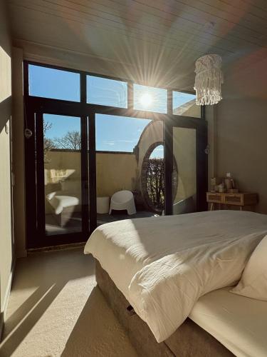 a bedroom with a large bed and a large window at Lizzy's B&B in Maarssen