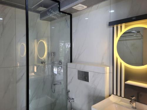 a bathroom with a shower and a sink and a mirror at The Cove Beach Resort in Cochin