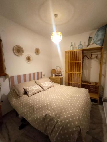a bedroom with a bed and a light on the ceiling at Casa Fuente del Caño in Casarabonela