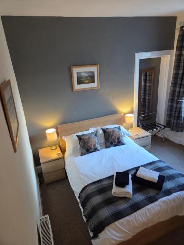 a bedroom with a bed with two dogs on the pillows at Ardgay in Fort Augustus