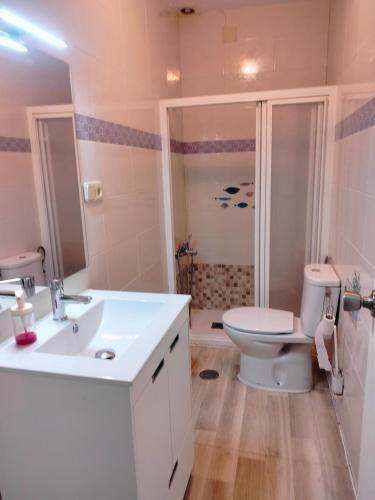 a bathroom with a white sink and a toilet at Casa Fuente del Caño in Casarabonela