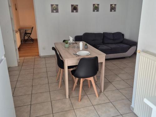 a table and chairs in a living room with a couch at Le lumineux-T2 calme-animaux acceptés-place auto in Saint-Gaudens