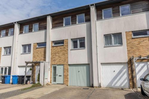 an exterior view of a building with two garages at Just Beachy - Moments from Hamworthy Beach and Park in Poole