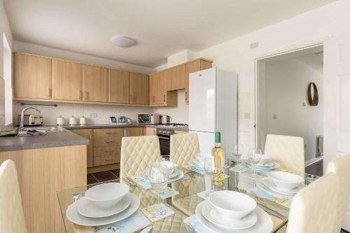 a kitchen with a glass table with white dishes on it at Just Beachy - Moments from Hamworthy Beach and Park in Poole
