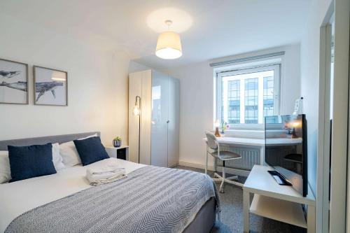 a bedroom with a bed and a desk and a table at Modern 3-Bedroom Apartment in Leeds City Centre - Sleeps 6 in Elland