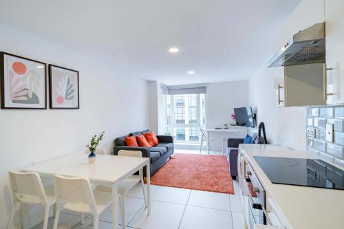 a kitchen and living room with a table and a couch at Modern 3-Bedroom Apartment in Leeds City Centre - Sleeps 6 in Elland