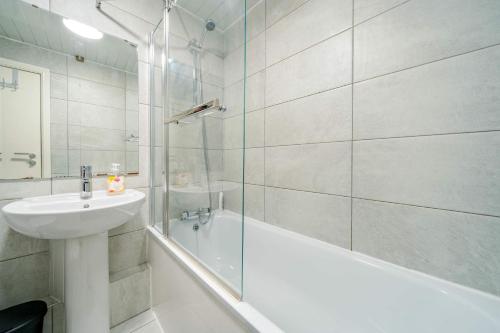 a bathroom with a sink and a tub and a shower at Modern 3-Bedroom Apartment in Leeds City Centre - Sleeps 6 in Elland