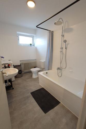 a bathroom with a tub and a toilet and a sink at Wohnen am Klinikum 2 in Oldenburg