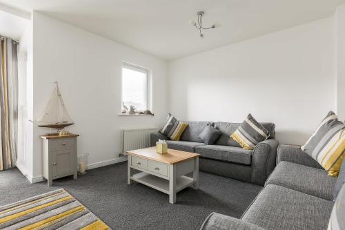 a living room with a couch and a table at Just Beachy - Moments from Hamworthy Beach and Park in Poole