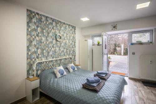 a bedroom with a bed with towels on it at Mirabella apartman in Csopak