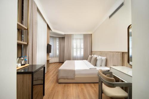 a hotel room with a bed and a desk at Atik Hotel Nişantaşı in Istanbul