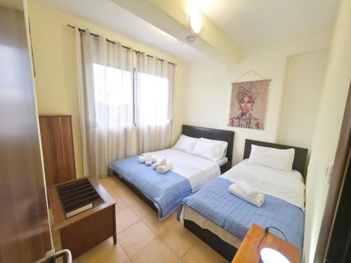 a hotel room with two beds and a window at Dalia Mare in Flogita