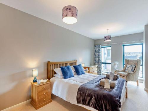 a bedroom with a large bed with blue pillows at 4 Bed in Talsarnau oc-96164 in Talsarnau