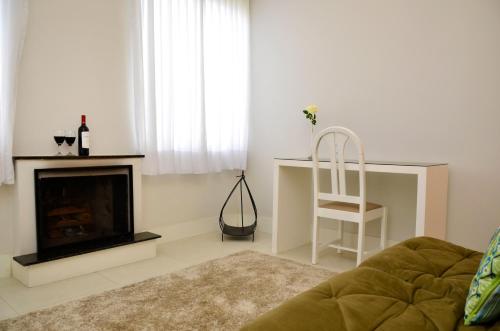 a living room with a fireplace and a chair at Hotel Girassol in Penedo
