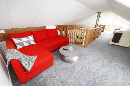 a living room with a red couch in a attic at 2 Bed in Gower oc-hh411 in Parkmill