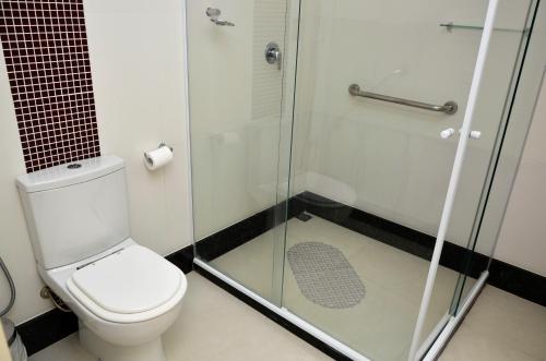 a bathroom with a toilet and a glass shower at Hotel Girassol in Penedo