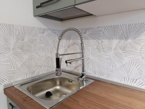 a kitchen sink with a faucet on a wall at Altea - Lago di Como nuovo accogliente mini appartamento vicino alla spiaggia e giardino in Dervio