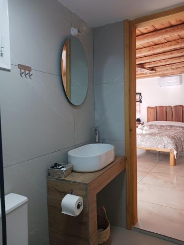 ein Badezimmer mit Waschbecken, Spiegel und Bett in der Unterkunft Thea Kapsali in Kapsálion
