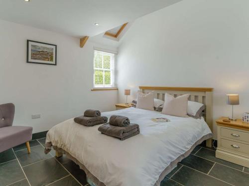 a bedroom with a large bed with towels on it at 3 Bed in Pembroke oc-82584 in Lamphey