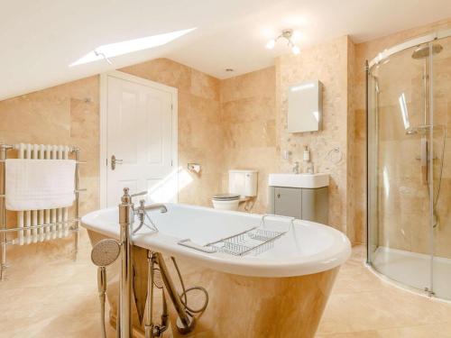 a bathroom with a tub and a shower and a sink at 9 Bed in Buxton oc-57932 in Buxton