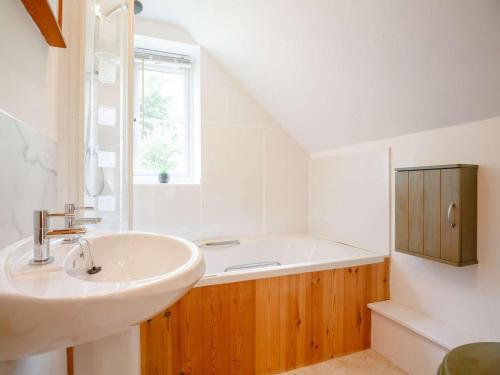 a bathroom with a sink and a bath tub at 4 Bed in Corwen oc-88868 in Corwen