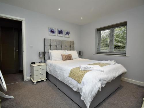 a bedroom with a large bed and a window at 4 Bed in Oswestry oc-74110 in Kinnerley