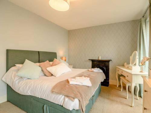 a bedroom with a large bed with a desk and a bed sidx sidx at 2 Bed in Milford Haven oc-88529 in Milford Haven