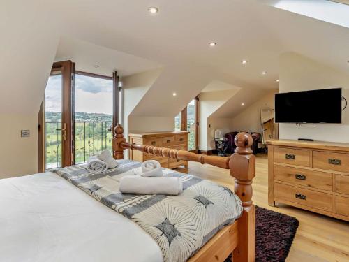 a bedroom with a large bed and a television at 2 Bed in Corwen oc-77351 in Corwen