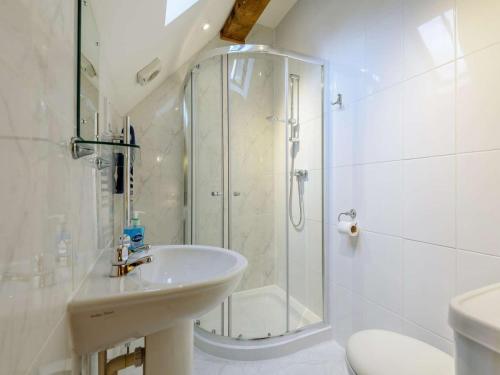 a white bathroom with a shower and a sink at 4 Bed in Newtown oc-86784 in Bettws Cedewain