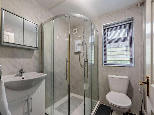 a bathroom with a shower and a toilet and a sink at 5 Bed in Llanybydder oc-75907 in Llanwenog