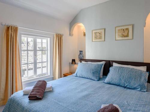 a bedroom with a blue bed with blue pillows and a window at 1 Bed in Presteigne oc-55285 in Presteigne