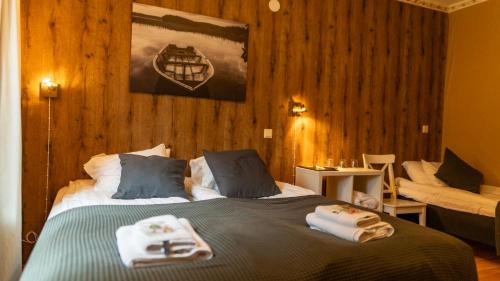 a bedroom with a bed with towels on it at Kartanohotelli Artturi in Söderkulla