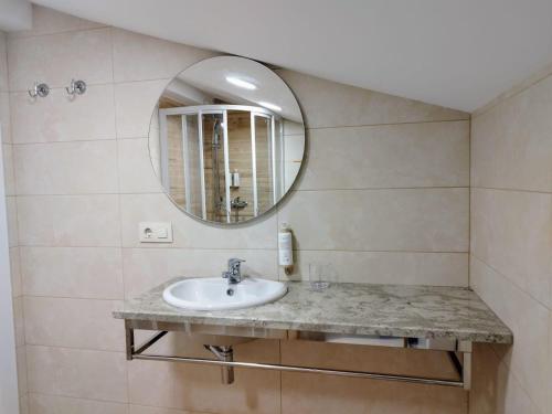a bathroom with a sink and a mirror at Alojamientos arans in La Cañiza