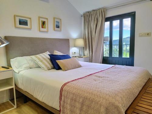 a bedroom with a large bed with a large window at Alojamientos arans in La Cañiza