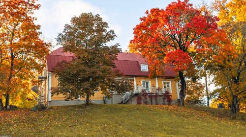 a house on a hill in the fall at Kartanohotelli Artturi in Söderkulla